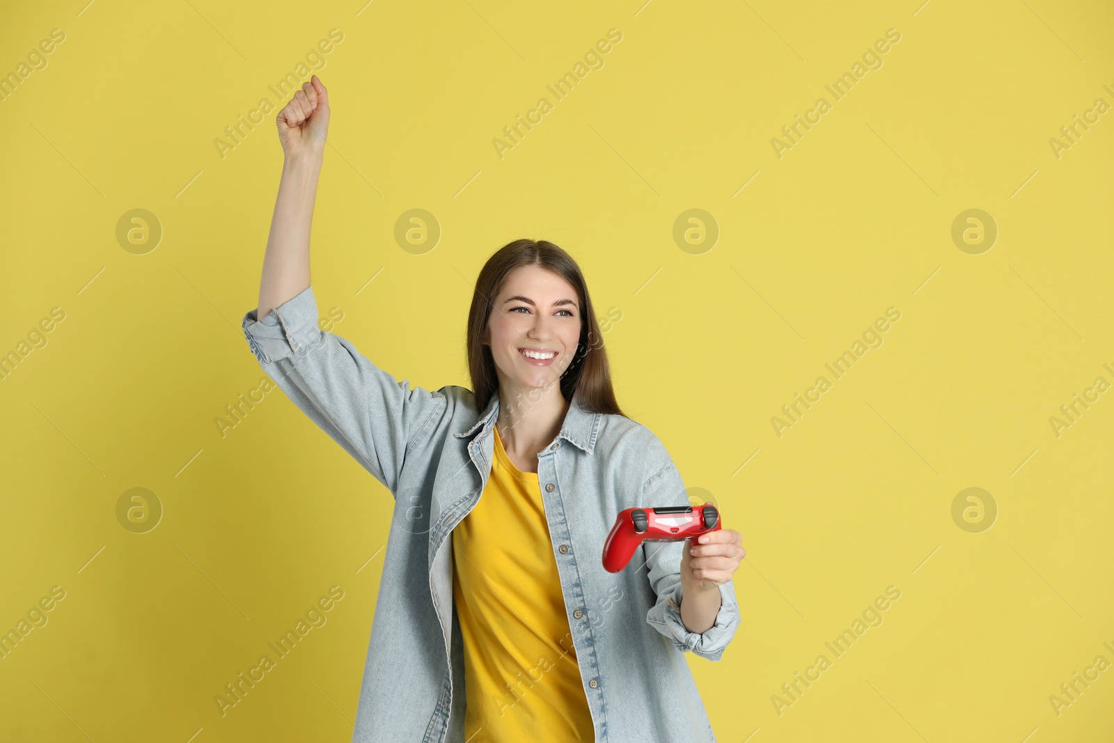 Photo of Happy woman with controller on yellow background