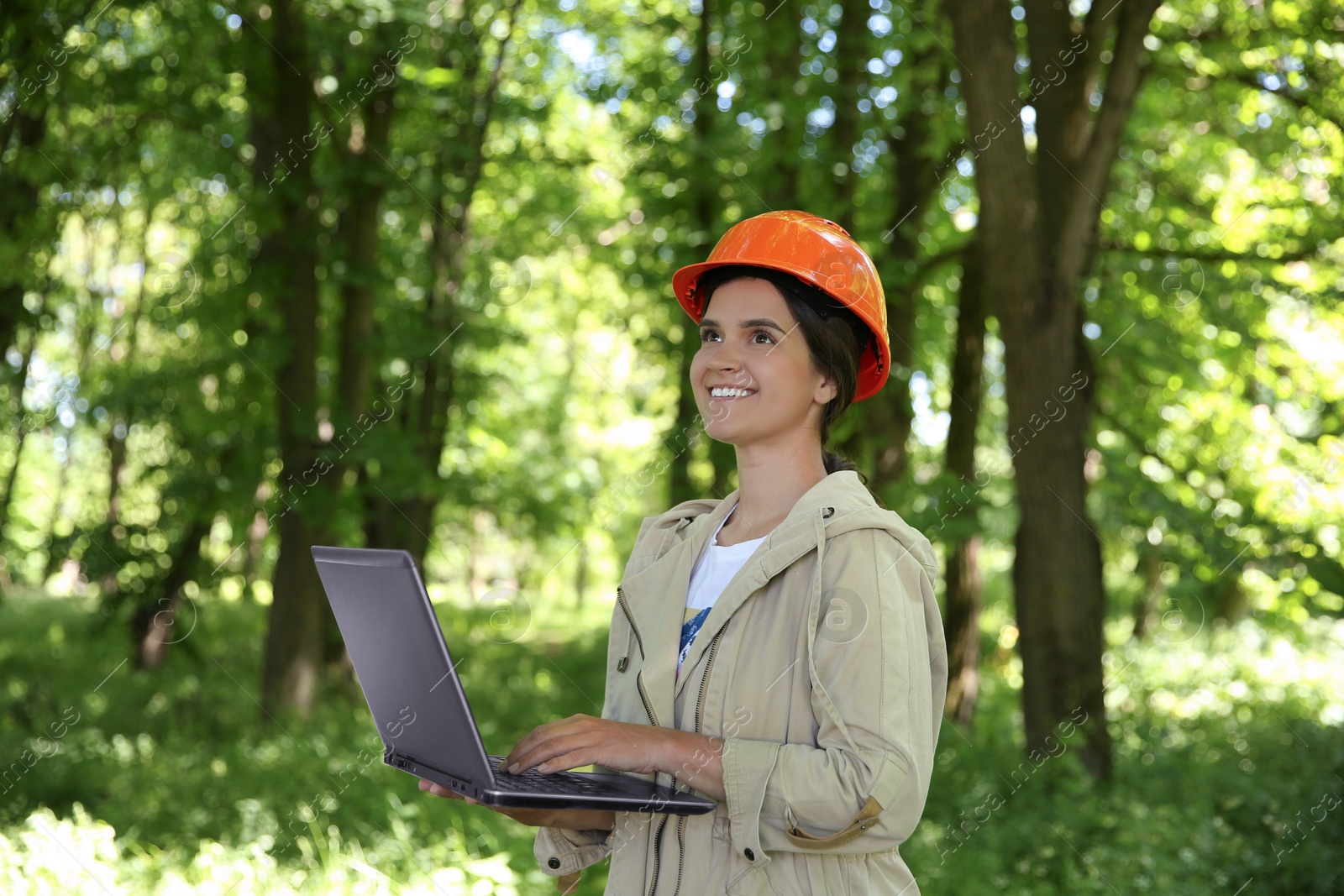 Photo of Forester with laptop examining plants in forest