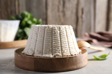 Fresh ricotta (cream cheese) on light grey table, closeup