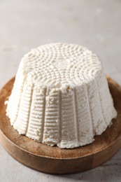 Photo of Fresh ricotta (cream cheese) on light grey table, closeup