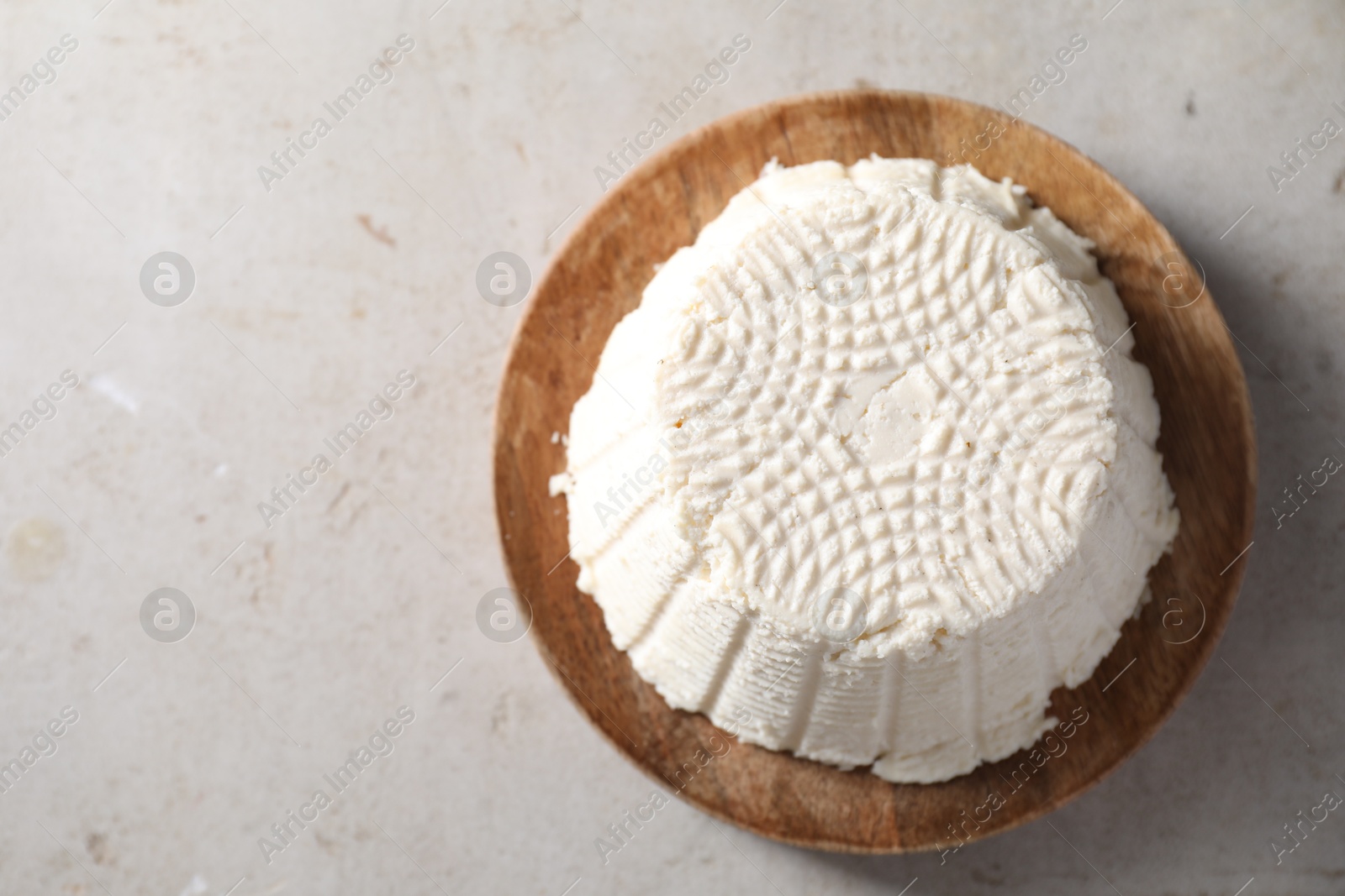 Photo of Fresh ricotta (cream cheese) on light grey table, top view. Space for text