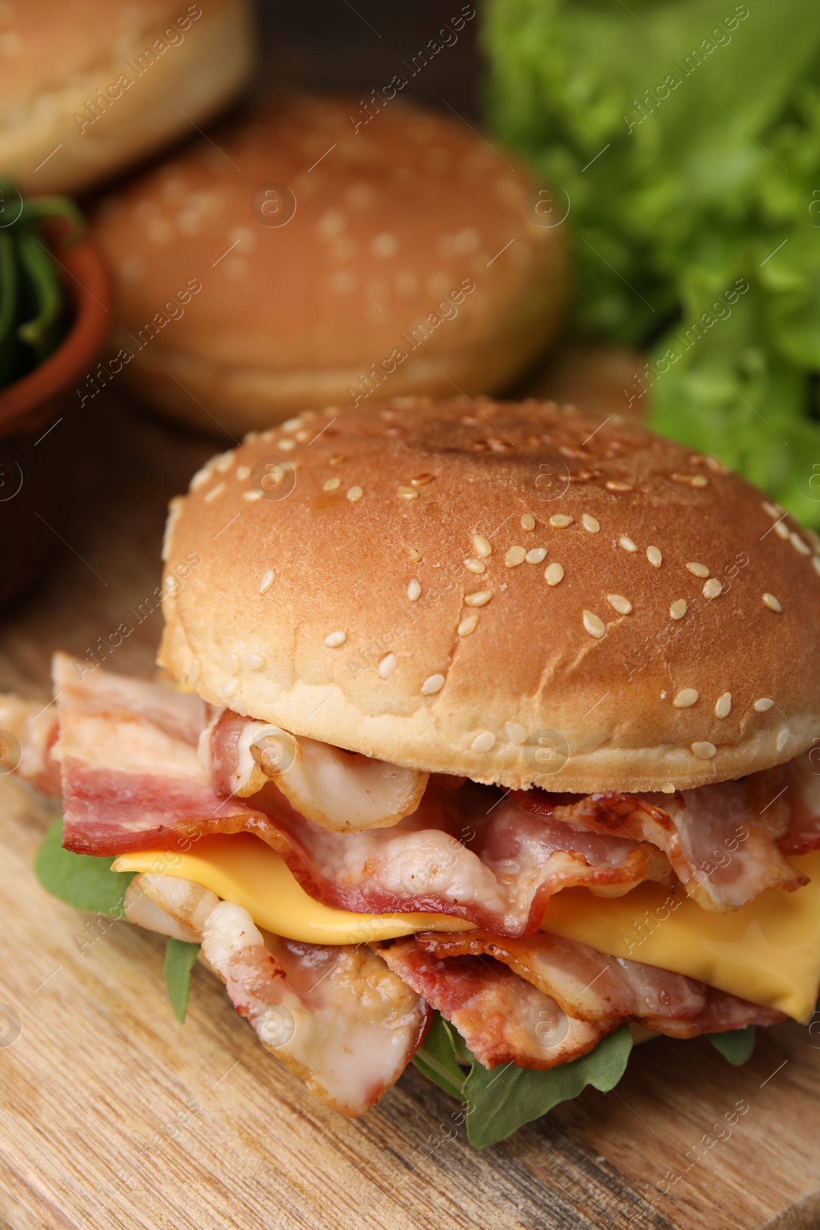 Photo of Delicious burger with bacon and cheese on table