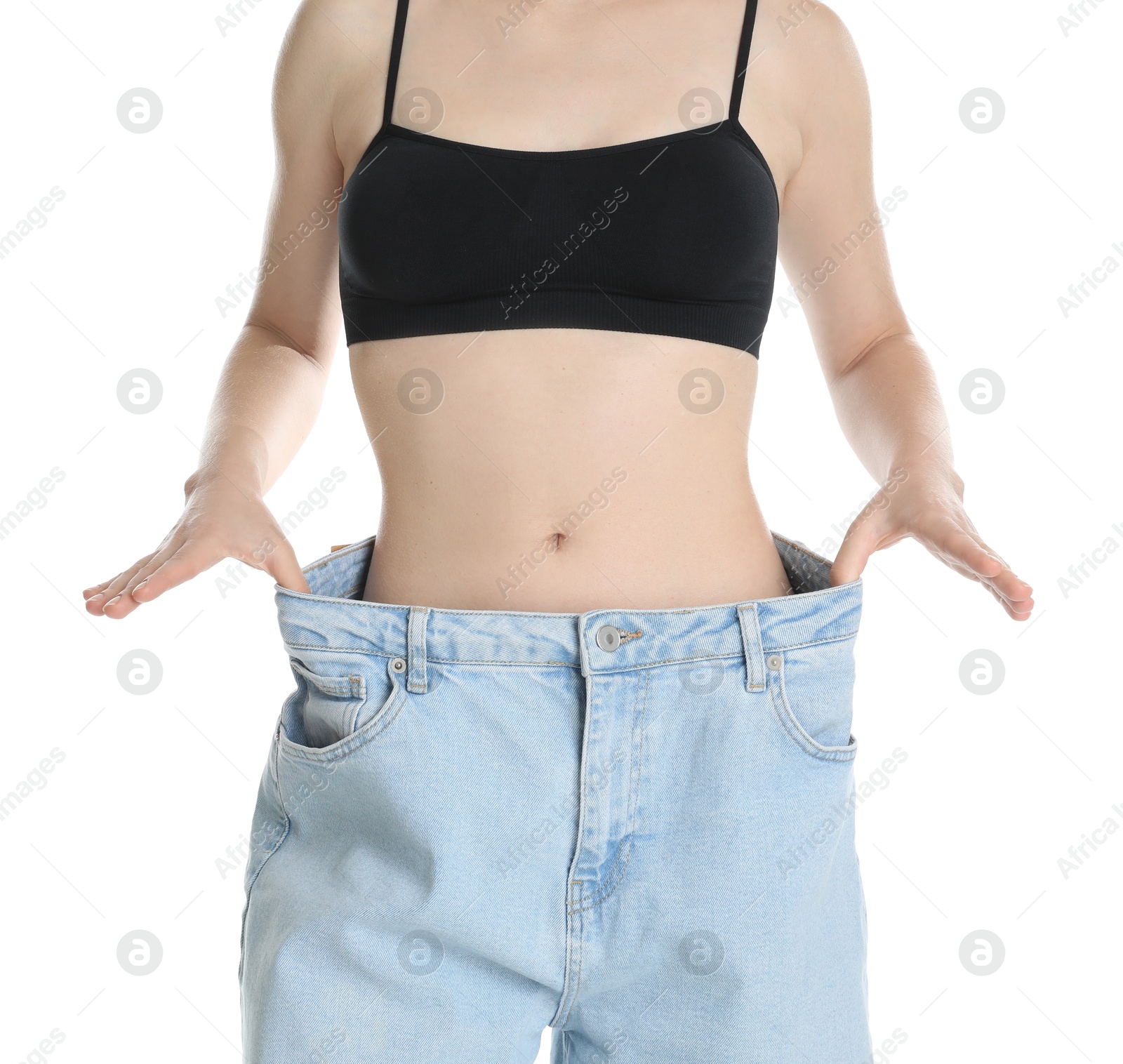 Photo of Woman in big jeans showing her slim body on white background, closeup