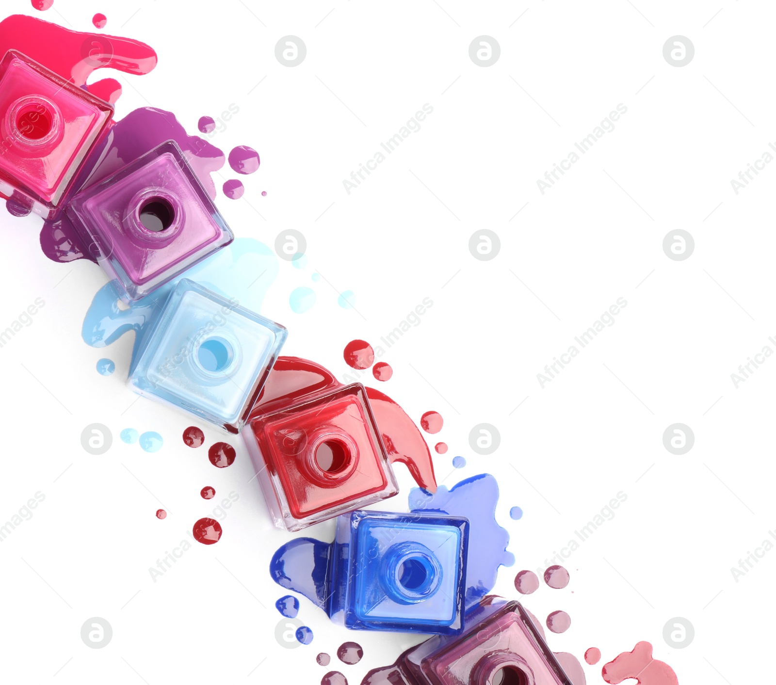 Photo of Many bottles and drops of colorful nail polishes isolated on white, top view