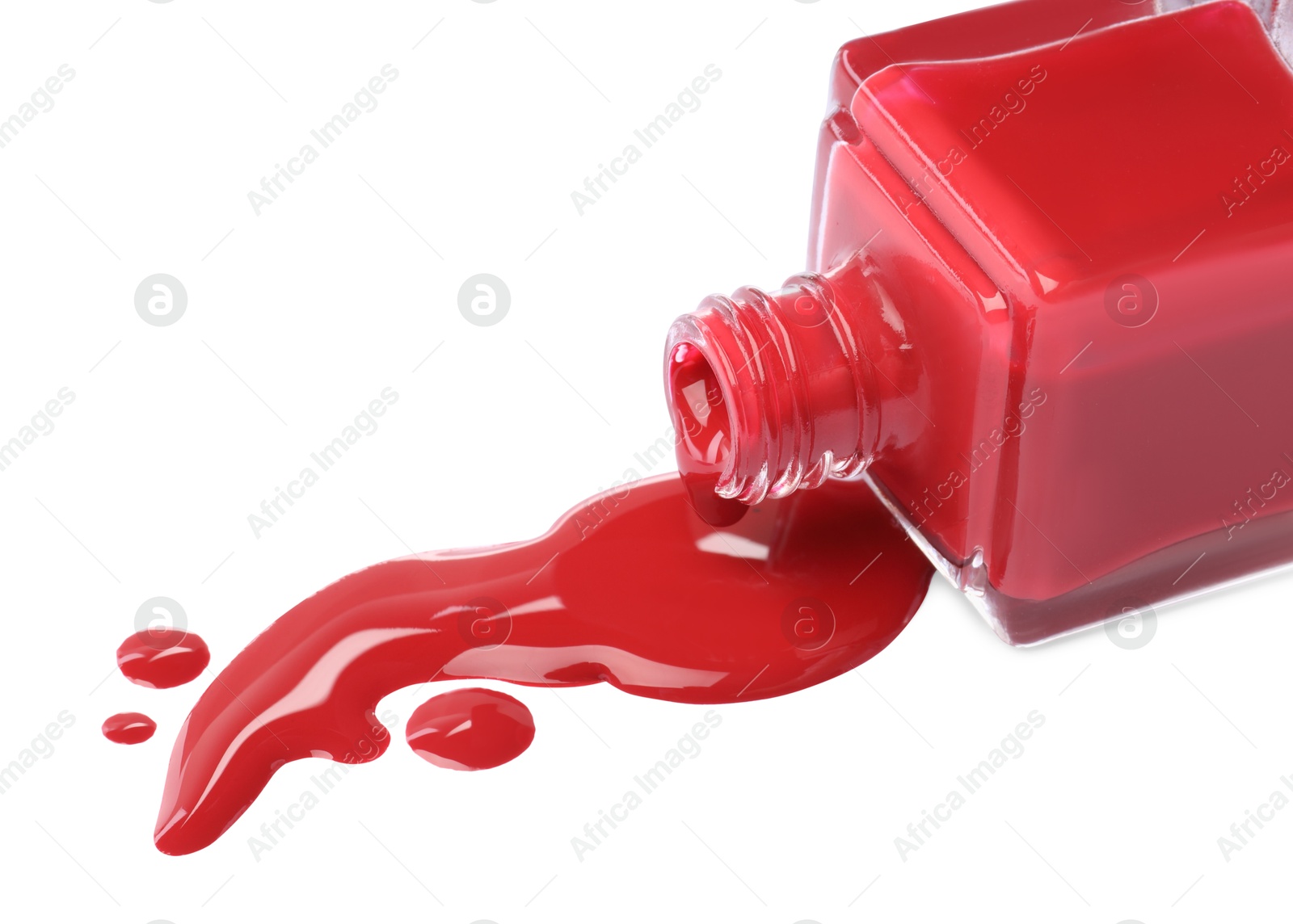 Photo of Bottle and spilled red nail polish isolated on white