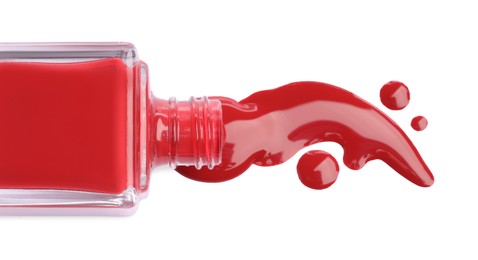 Bottle and spilled red nail polish isolated on white, top view