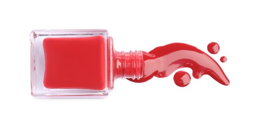 Photo of Bottle and spilled red nail polish isolated on white, top view