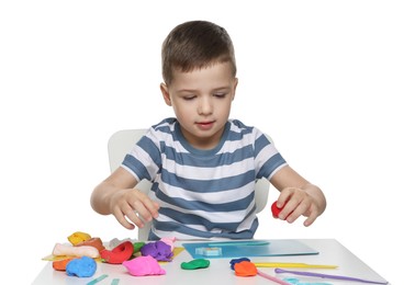 Little boy sculpting with play dough at table on white background