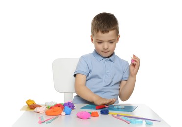 Photo of Little boy sculpting with play dough at table on white background