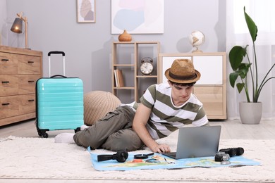 Travel blogger using laptop for planning trip at home