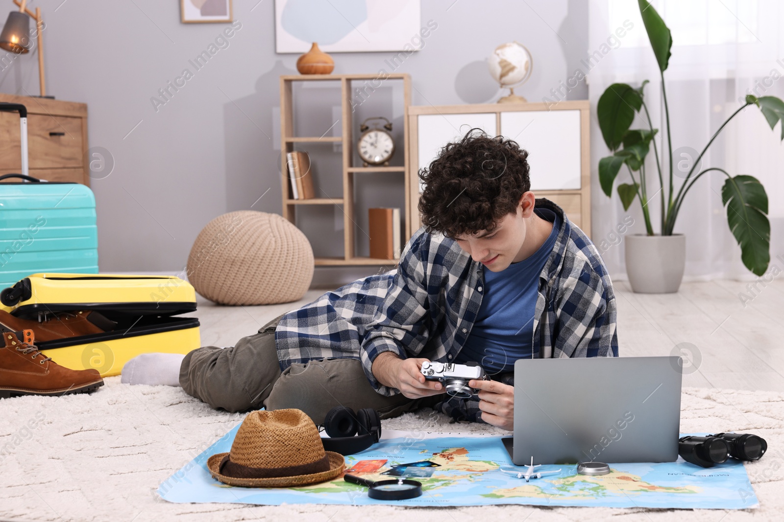 Photo of Travel blogger with vintage camera and other items for trip at home