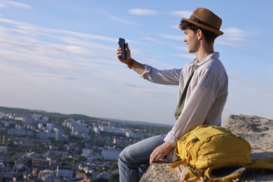 Photo of Travel blogger takIng selfie with smartphone outdoors