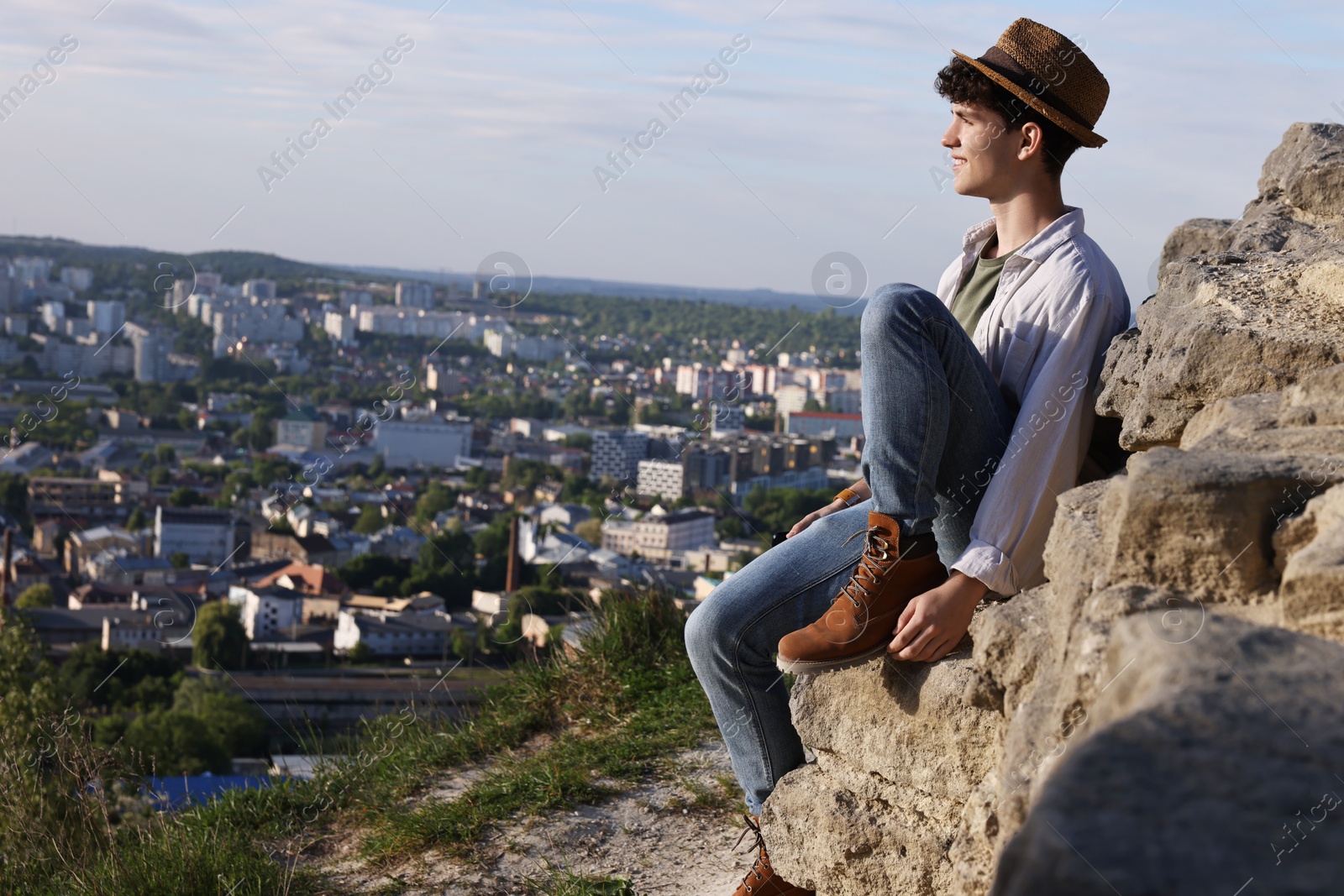 Photo of Travel blogger on stone looking at beautiful view outdoors, space for text