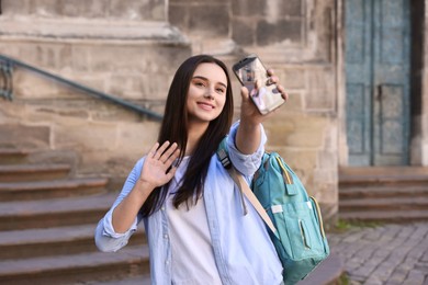 Photo of Beautiful travel blogger with smartphone streaming outdoors