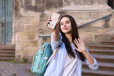 Photo of Beautiful travel blogger with smartphone streaming outdoors