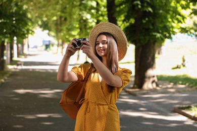 Travel blogger takIng picture with vintage camera outdoors