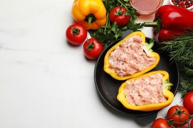 Photo of Raw stuffed peppers with ground meat and ingredients on white marble table, flat lay. Space for text