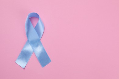 Photo of International Psoriasis Day. Ribbon as symbol of support on pink background, top view. Space for text