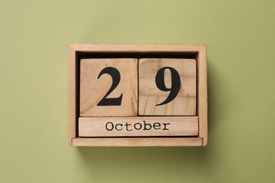 Photo of International Psoriasis Day - 29th of October. Block calendar on green background, top view