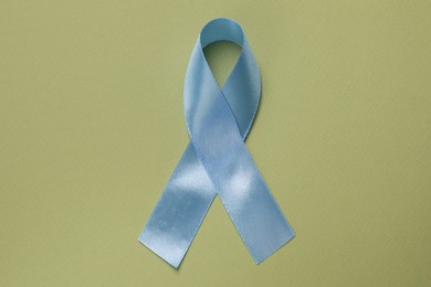 Photo of International Psoriasis Day. Ribbon as symbol of support on green background, top view