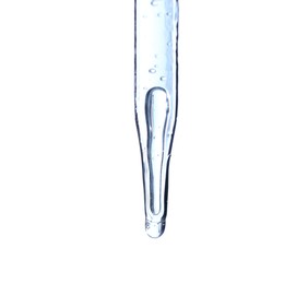 Dripping liquid from pipette on light blue background, closeup