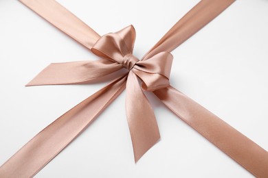 Beige satin ribbon with bow on white background