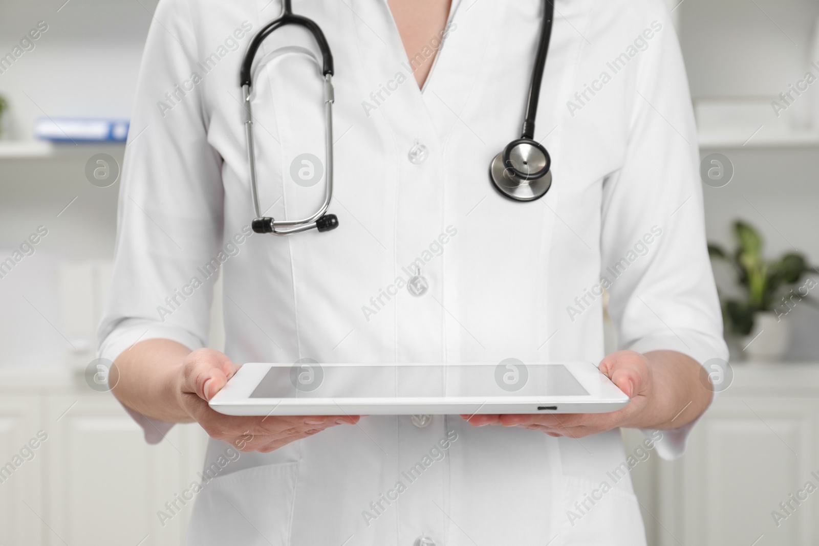 Photo of Doctor with tablet in clinic, closeup view