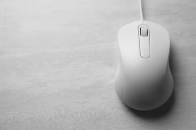 Photo of One wired mouse on grey wooden table, above view. Space for text