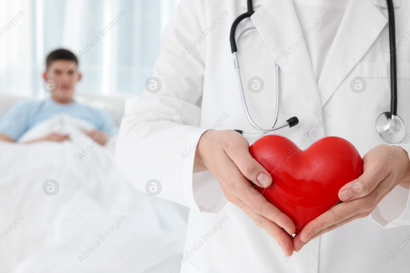 Photo of Doctor holding red heart in clinic, selective focus