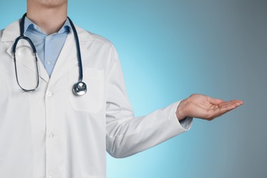 Doctor holding something on light blue background, closeup