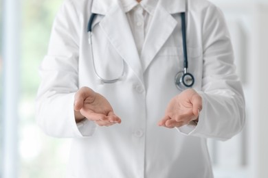 Photo of Doctor with stethoscope holding something in clinic, closeup