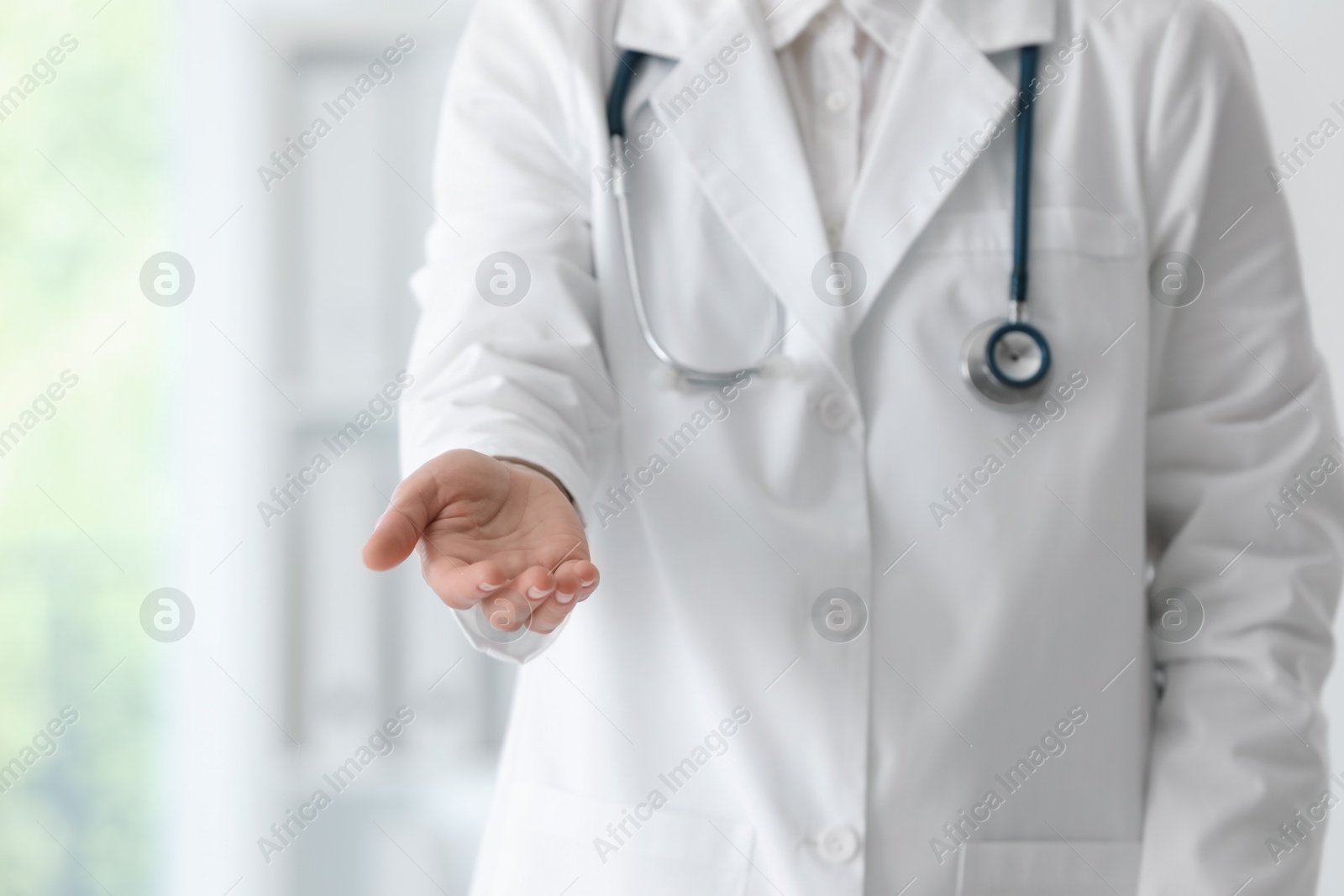 Photo of Doctor with stethoscope holding something in clinic, closeup