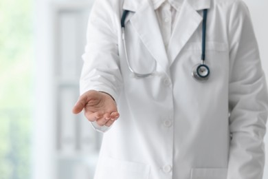 Photo of Doctor with stethoscope holding something in clinic, closeup