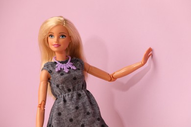 Photo of Mykolaiv, Ukraine - September 4, 2023: Beautiful Barbie doll wearing necklace on violet background, space for text