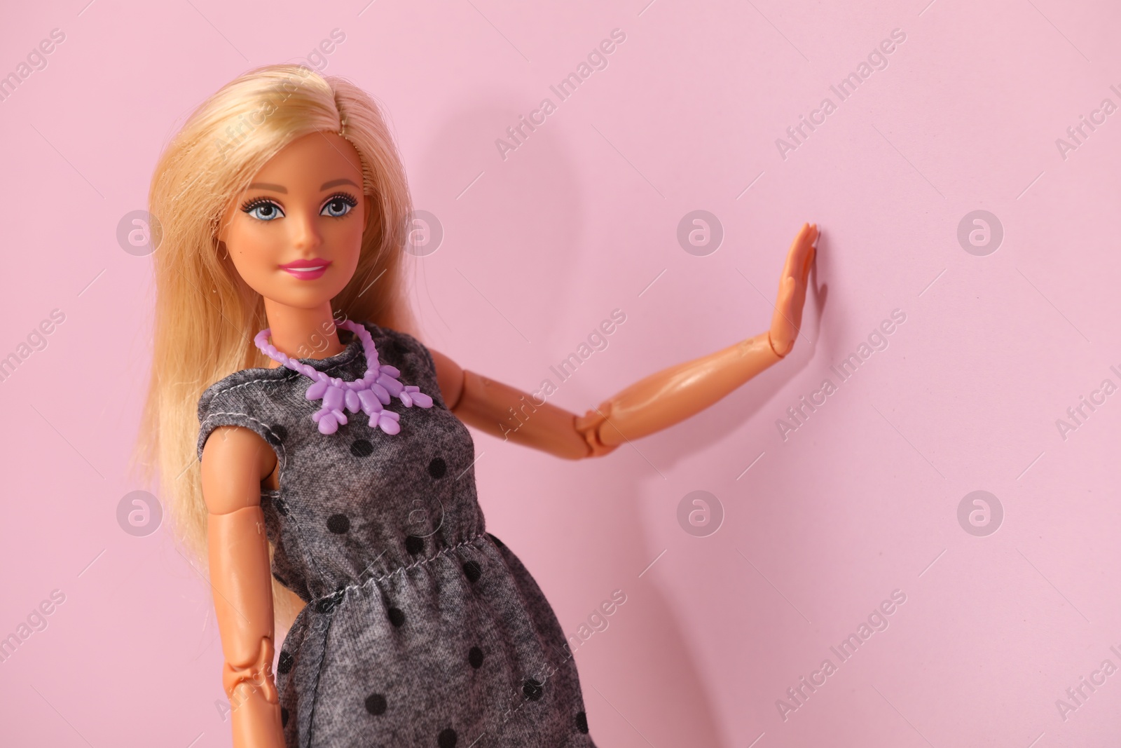 Photo of Mykolaiv, Ukraine - September 4, 2023: Beautiful Barbie doll wearing necklace on violet background, space for text