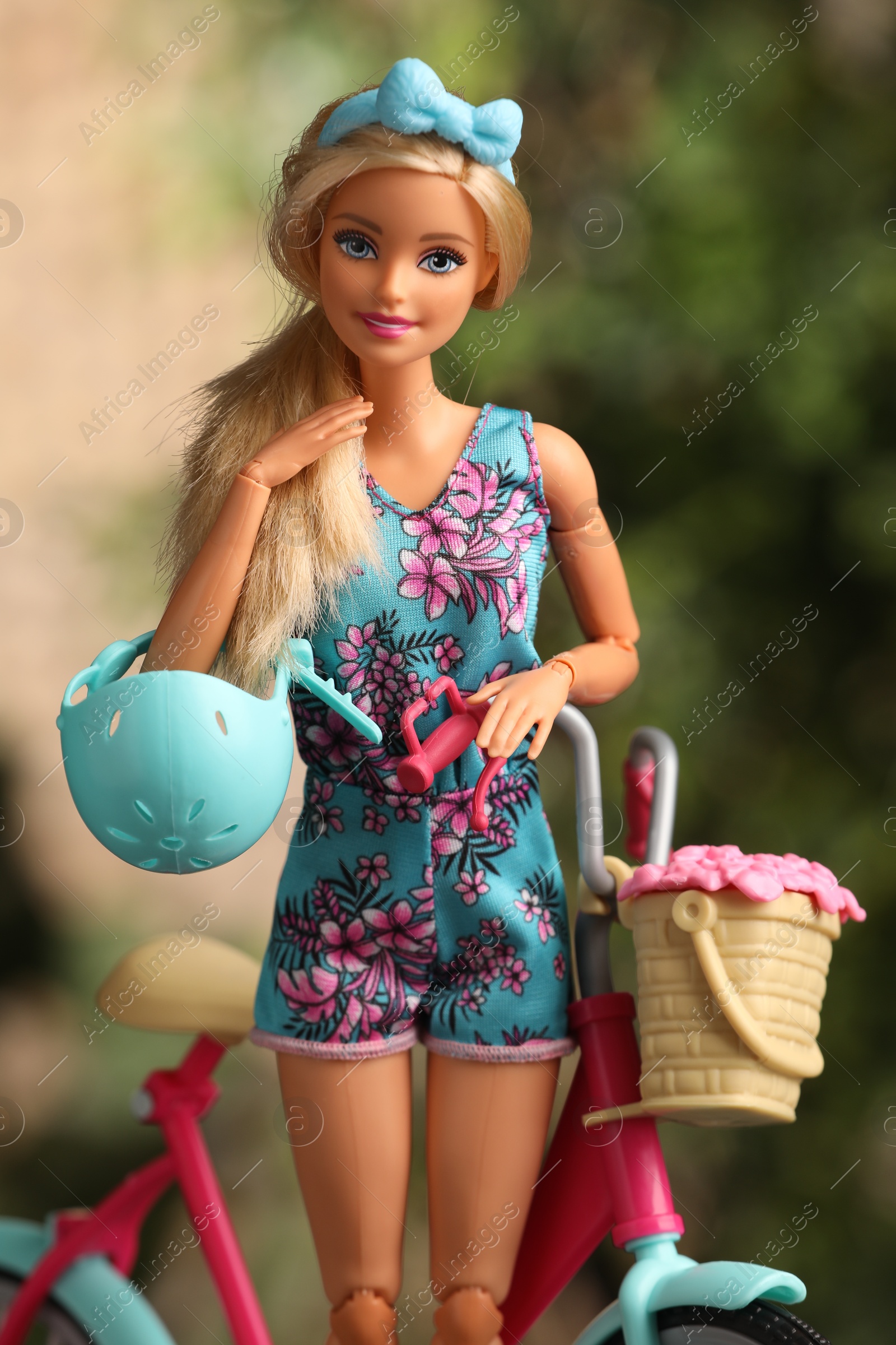 Photo of Mykolaiv, Ukraine - September 4, 2023: Beautiful Barbie doll with helmet and bicycle on blurred background