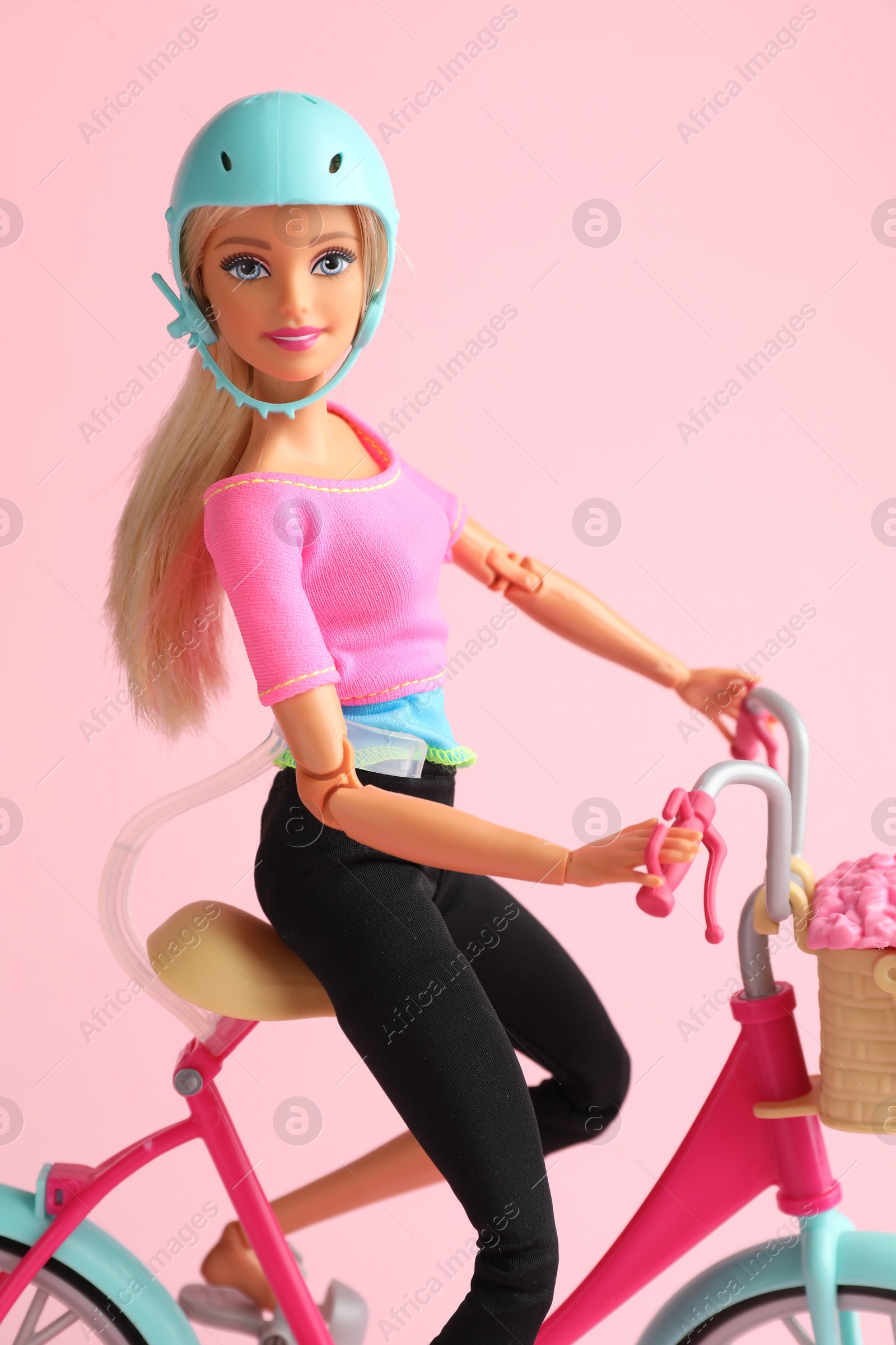 Photo of Mykolaiv, Ukraine - September 2, 2023: Beautiful Barbie doll with bicycle on pink background
