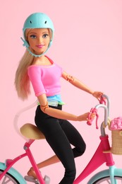 Mykolaiv, Ukraine - September 2, 2023: Beautiful Barbie doll with bicycle on pink background