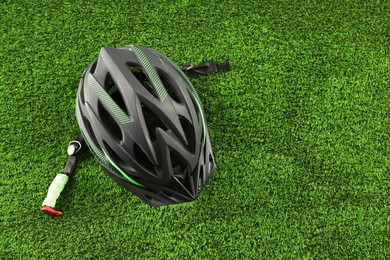Stylish protective helmet on green grass, top view. Space for text