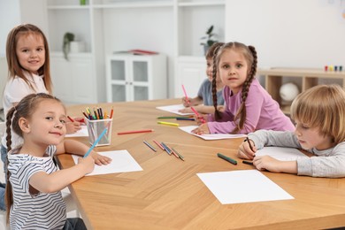 Photo of Group of children drawing at wooden table indoors