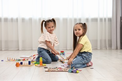 Photo of Cute little children playing together on floor indoors