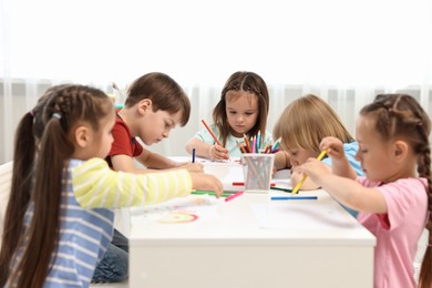 Group of children drawing at table indoors