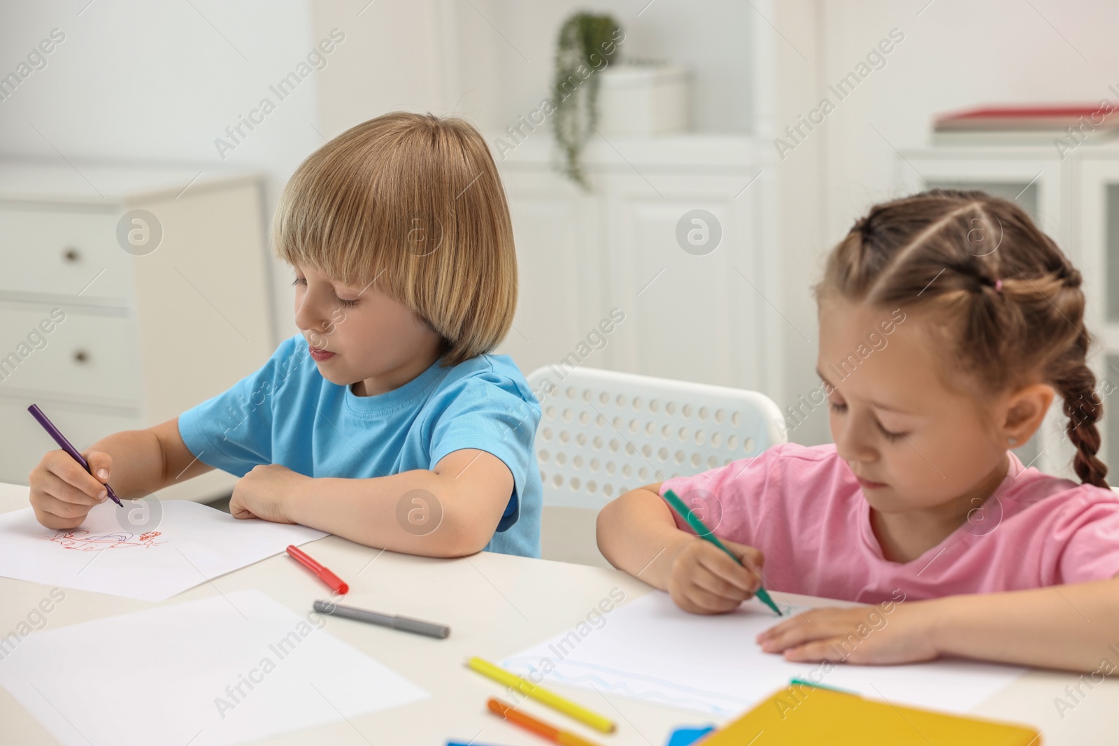 Photo of Cute little children drawing at table indoors