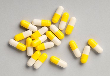 Photo of Many antibiotic pills on grey background, top view. Medicinal treatment