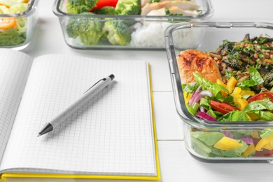 Photo of Healthy meal. Open notebook and containers with different products on white wooden table