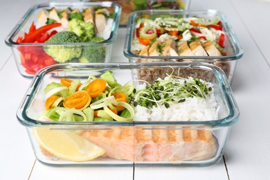 Photo of Healthy meal. Containers with different products on white wooden table, closeup