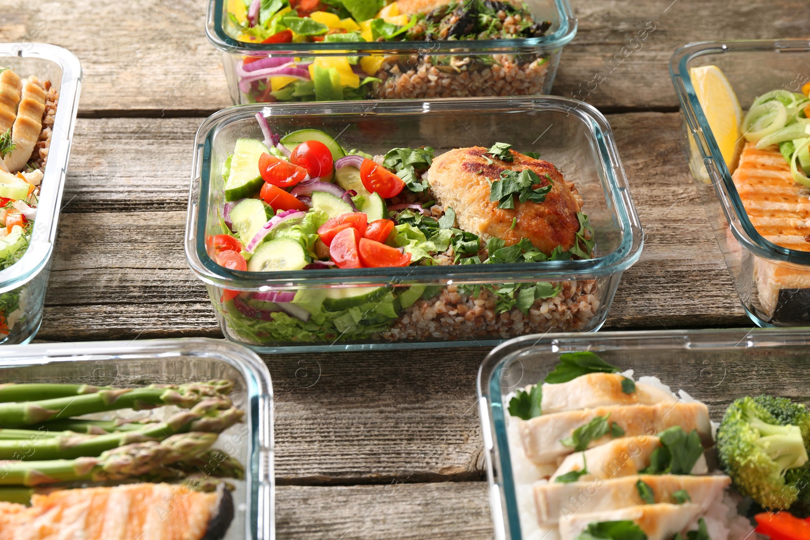 Photo of Healthy meal. Containers with different products on wooden table