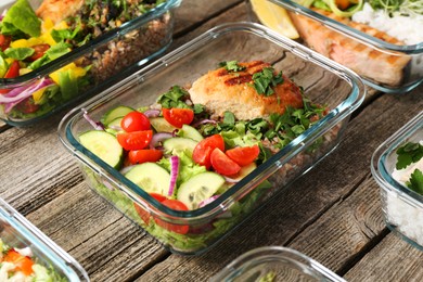 Photo of Healthy meal. Containers with different products on wooden table, closeup