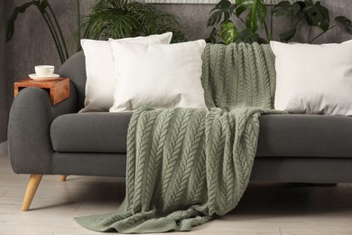 Photo of Soft white pillows and blanket on sofa indoors