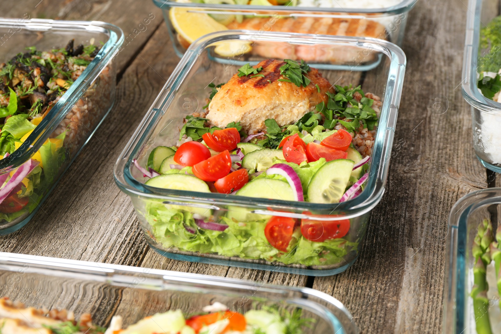 Photo of Healthy meal. Containers with different products on wooden table, closeup